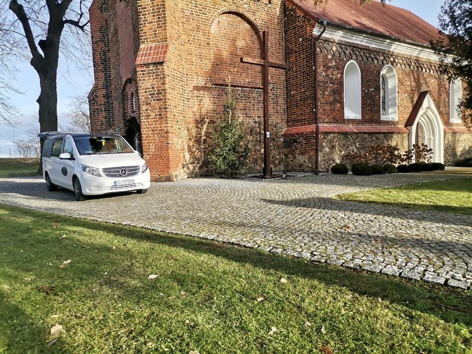 pogrzeby polkowice biała karawana stojąca pod kościołem przed pogrzebem w polkowicach